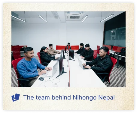 A software development team working together at a modern office, seated around rows of desks with computer monitors. The image features the caption “The team behind Nihongo Nepal,” highlighting the people involved in developing and supporting the Nihongo Nepal app.