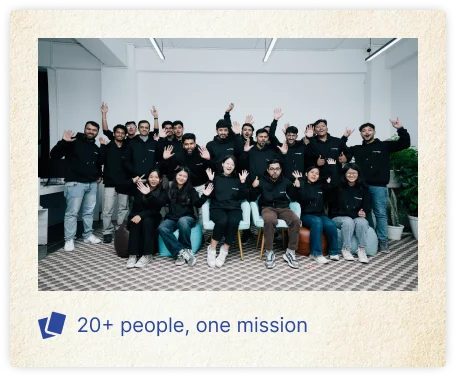 A large group of Nihongo Nepal team members posing together in a modern office, with several people raising their hands and smiling at the camera. The image features the caption “20+ people, one mission,” highlighting the size and shared purpose of the team.